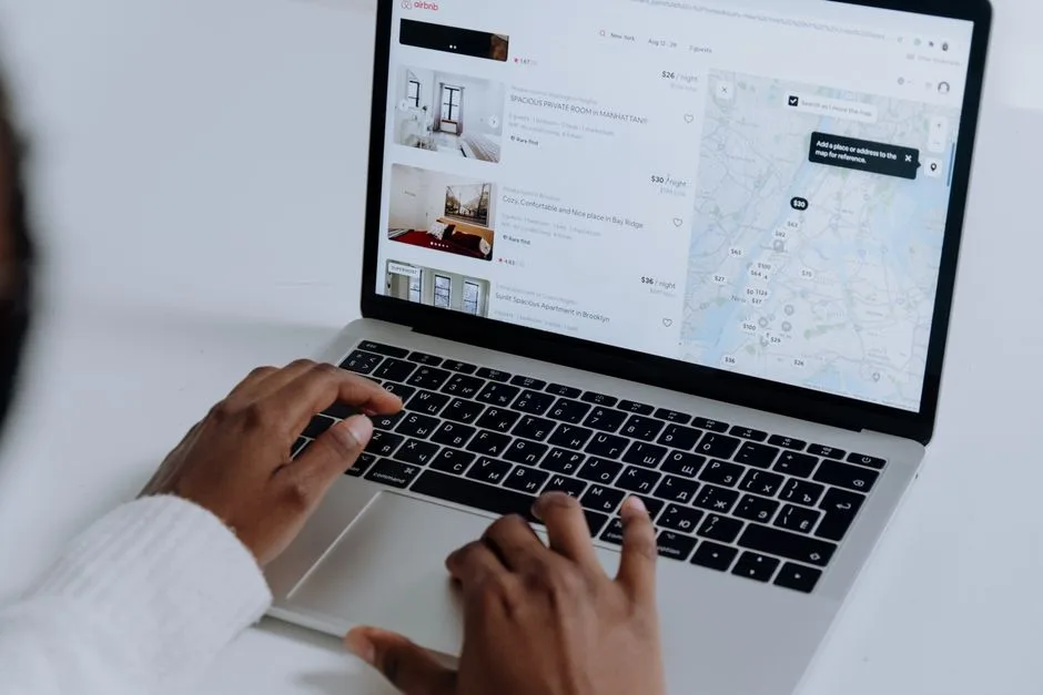 Person browsing pet-friendly rental listings on laptop at home with dog nearby