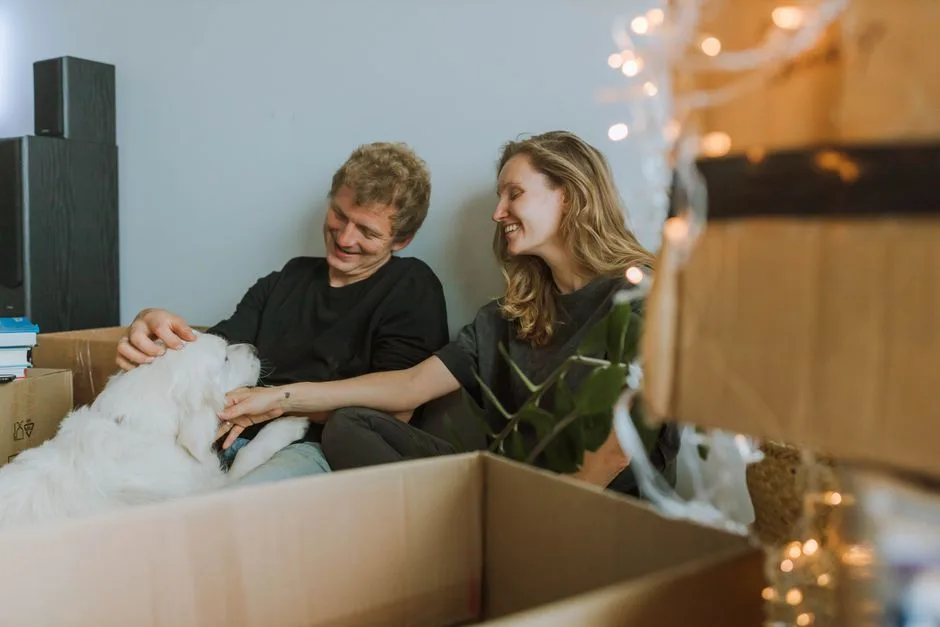 Happy dog owner sitting with their dog in a bright, modern apartment living room